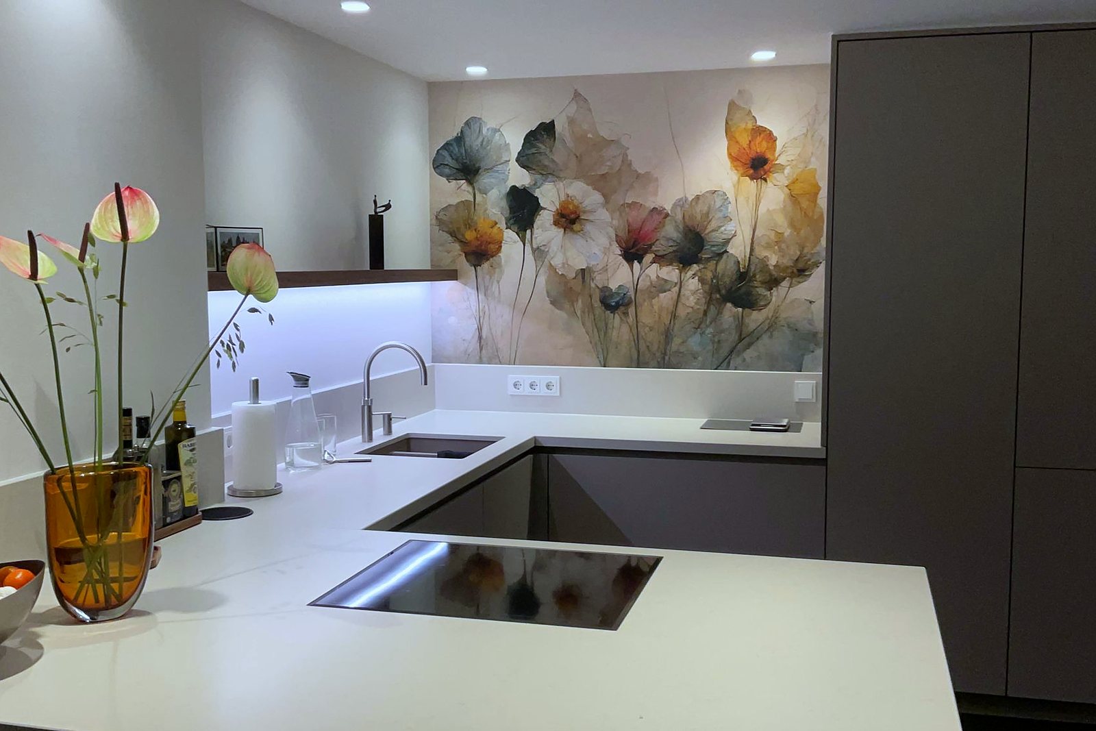 Keuken met taupe fronten en wit werkblad in hoekopstelling met achterwand met bloemenprint, door Maatmakers Interieurbouw