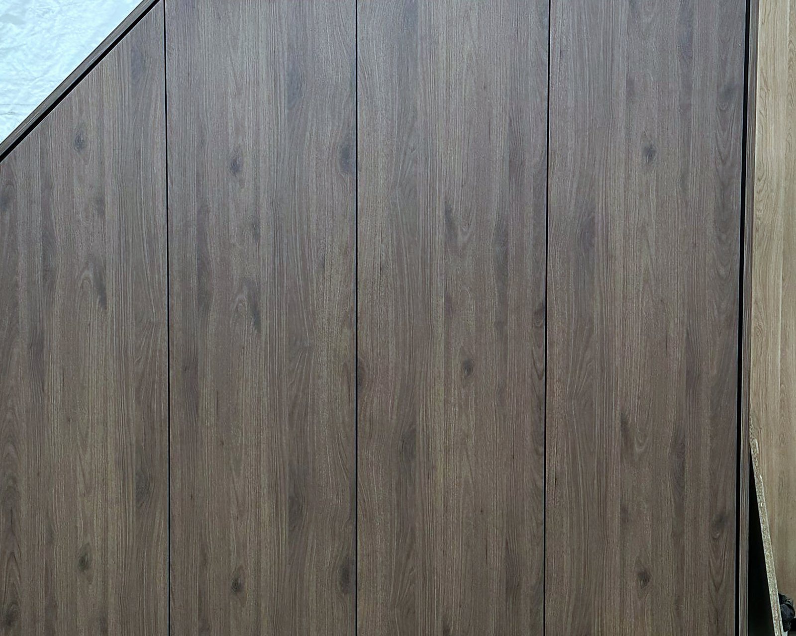 Kastwand in walnoot onder een trap uit de eigen werkplaats, door Maatmakers Interieurbouw